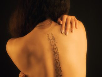 woman with black floral tattoo on her back