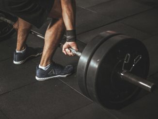 A man lifting a heavy barbell during a gym workout, showcasing strength and fitness.